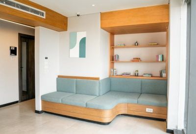 A built-in teal cushioned bench seat framed by light wood shelving and neutral decor.
