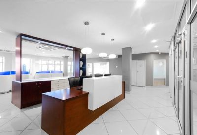 Modern reception area with a wood-fronted desk and white tiled floors.