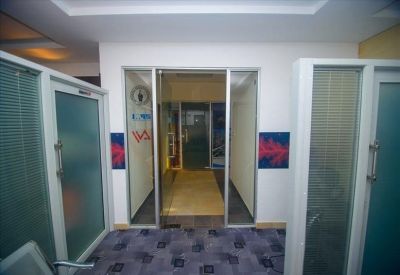 Office hallway with glass doors and blue patterned carpet.