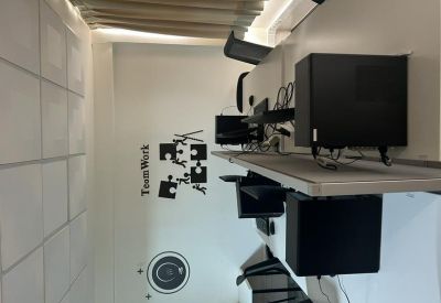 Row of desks featuring black computer towers and teamwork wall decal.