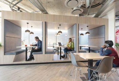 Private work pods built into a light wood wall with comfortable bench seating.