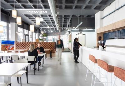 Spacious coworking cafe area with hanging pendant lights and a white counter.