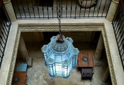 High-angle view of a traditional courtyard with a large blue lantern and tiled fountain.