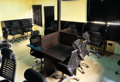 Open-plan office with multiple desks and chairs.