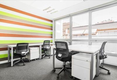 Bright coworking space featuring a vibrant striped feature wall and white desks.