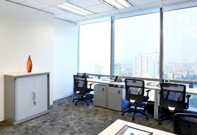 Bright office workstations with computers, ergonomic chairs, and large windows overlooking the city.