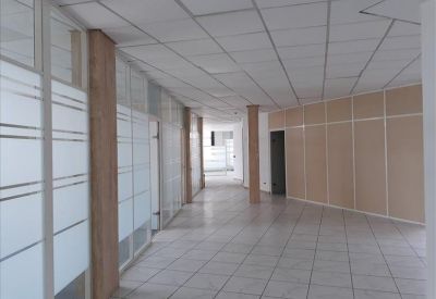 Bright corridor with glass partitions and tiled flooring.