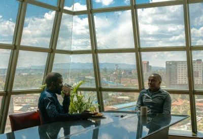 Bright communal lounge area with a glass wall overlooking the city skyline.