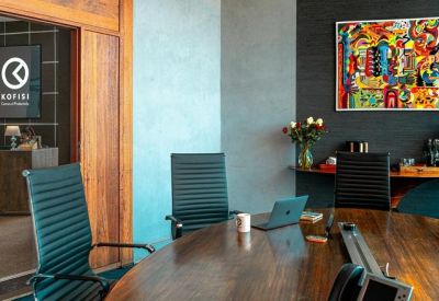 Meeting room with a large wooden table and colorful abstract wall art.