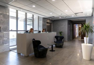 Spacious building lobby featuring a minimalist reception counter and comfortable seating area.