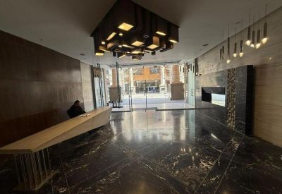 Modern lobby with a sleek geometric reception desk and artistic hanging light fixtures.