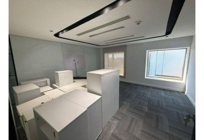 Private office space with grey carpet tiles and white storage cabinets.