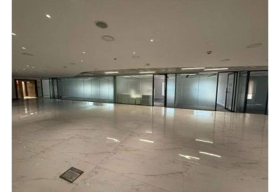 Bright open-plan corridor featuring glass-partitioned private office suites.