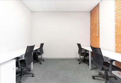 Private office suite with two white desks and ergonomic black chairs.