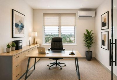 Private office with a light wood desk, ergonomic chair, and air conditioning unit.