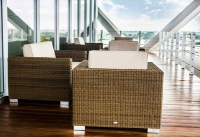 Outdoor terrace with wicker sofas and white cushions overlooking the city.