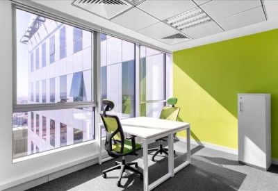 Bright corner office with lime green accent wall and two white desks.