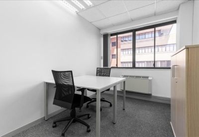 Private two-person office with white desks and mesh chairs.