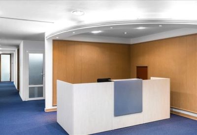 Clean, white reception desk with a blue accent panel against a wood-paneled wall.