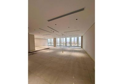 Spacious, modern open-plan office shell with polished floors and floor-to-ceiling windows.