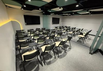 Training room with tiered seating and curved wall lighting.
