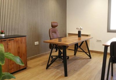 Modern private office with wood-slat feature wall and a brown leather chair.