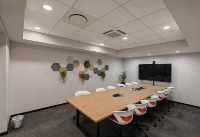Mezzanine level workspace overlooking a bright communal atrium with a large arched window.