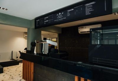 Self-service coffee bar and reception counter with overhead menu board.