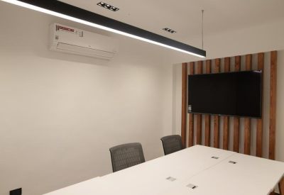 Meeting space featuring a wall-mounted flat screen on a decorative wood slat wall.