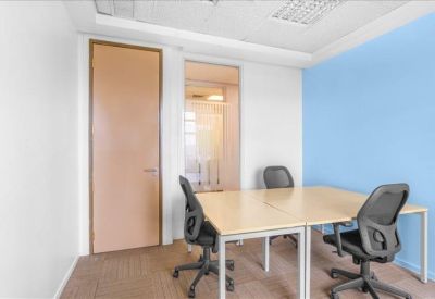 Private office suite with blonde wood desks and a light blue accent wall.