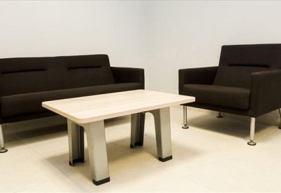 Lounge area with a dark grey sofa, armchair, and light wood coffee table.