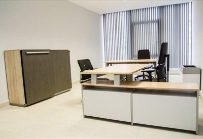 Private office suite featuring a light wood desk and grey storage cabinet.