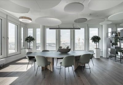 Communal meeting area with an oval table and unique circular acoustic ceiling panels.