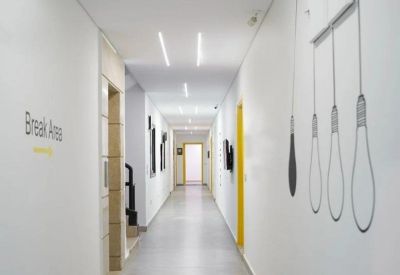 Modern corridor with recessed linear lighting and lightbulb wall graphics.