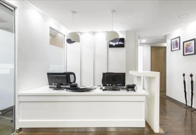Reception area with white desk and black computer monitors.