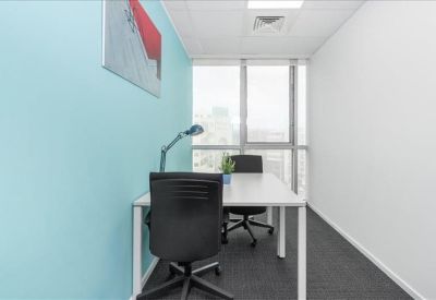 Internal two-person office suite with a teal feature wall and desk lamp.