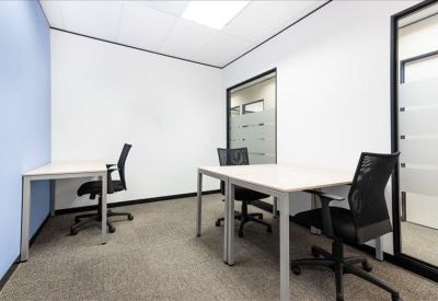 Bright private office suite with two white desks and black mesh chairs.