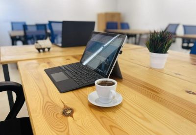 Wooden workstation with a laptop and a fresh cup of coffee.