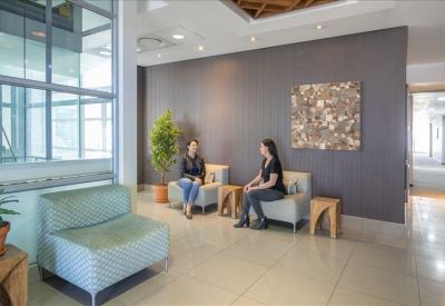 Spacious lobby with a café area, white modern furniture, and natural light.