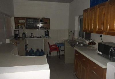 Kitchen and breakout area at Race Course Lapaz, Accra with wooden cabinetry and coffee station.