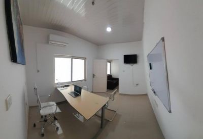 Private office suite with a wooden desk, laptop, and whiteboard.