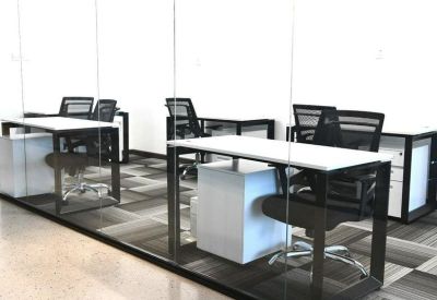 Private office suite with white desks and glass partitions.