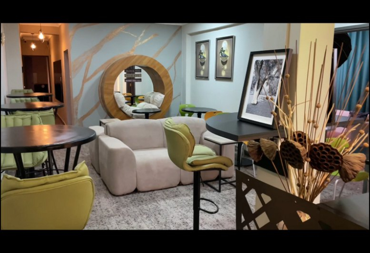 Spacious communal lounge at Bemud,, featuring a circular wood-framed reading nook and green velvet chairs.