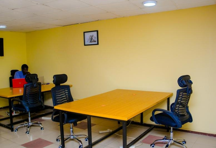 Open-plan workspace at Cocoa House with yellow desks and ergonomic black chairs.