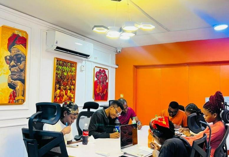 Team meeting at a large white table in a vibrant office at 29, 204 Road, Festac Town.