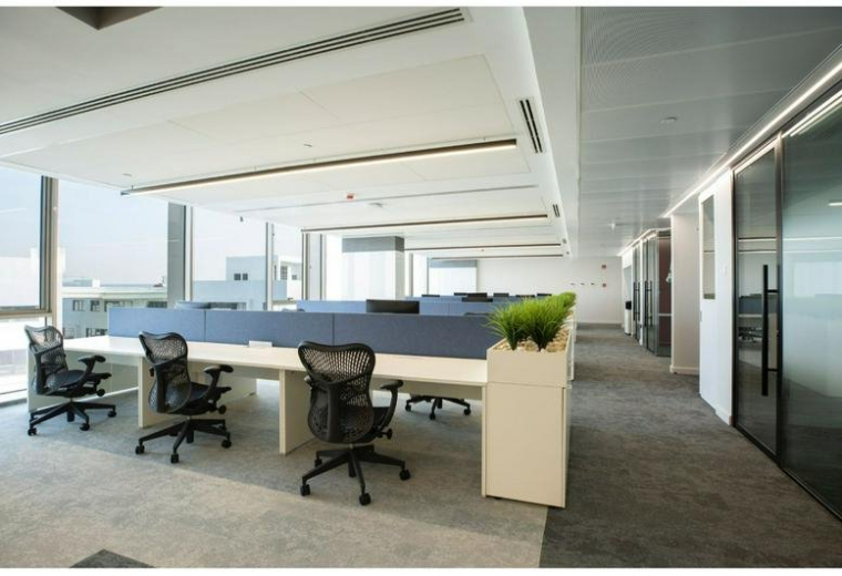 Open-plan office space at Building 7, 5A, Ring Road featuring ergonomic chairs and blue privacy screens.