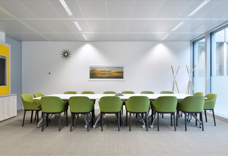 Spacious meeting room with green chairs and a long white table at Kentro One, Plot 3, Service Area 1.