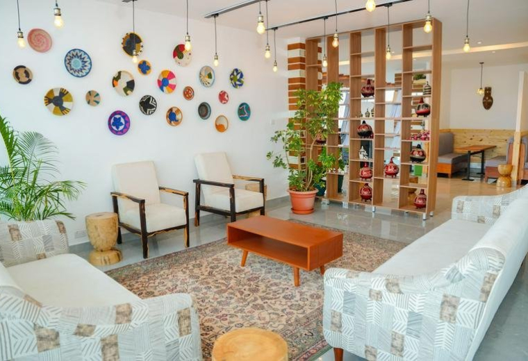 Spacious reception lounge at Highway Heights Kilimani with colorful wall baskets and plush sofas.