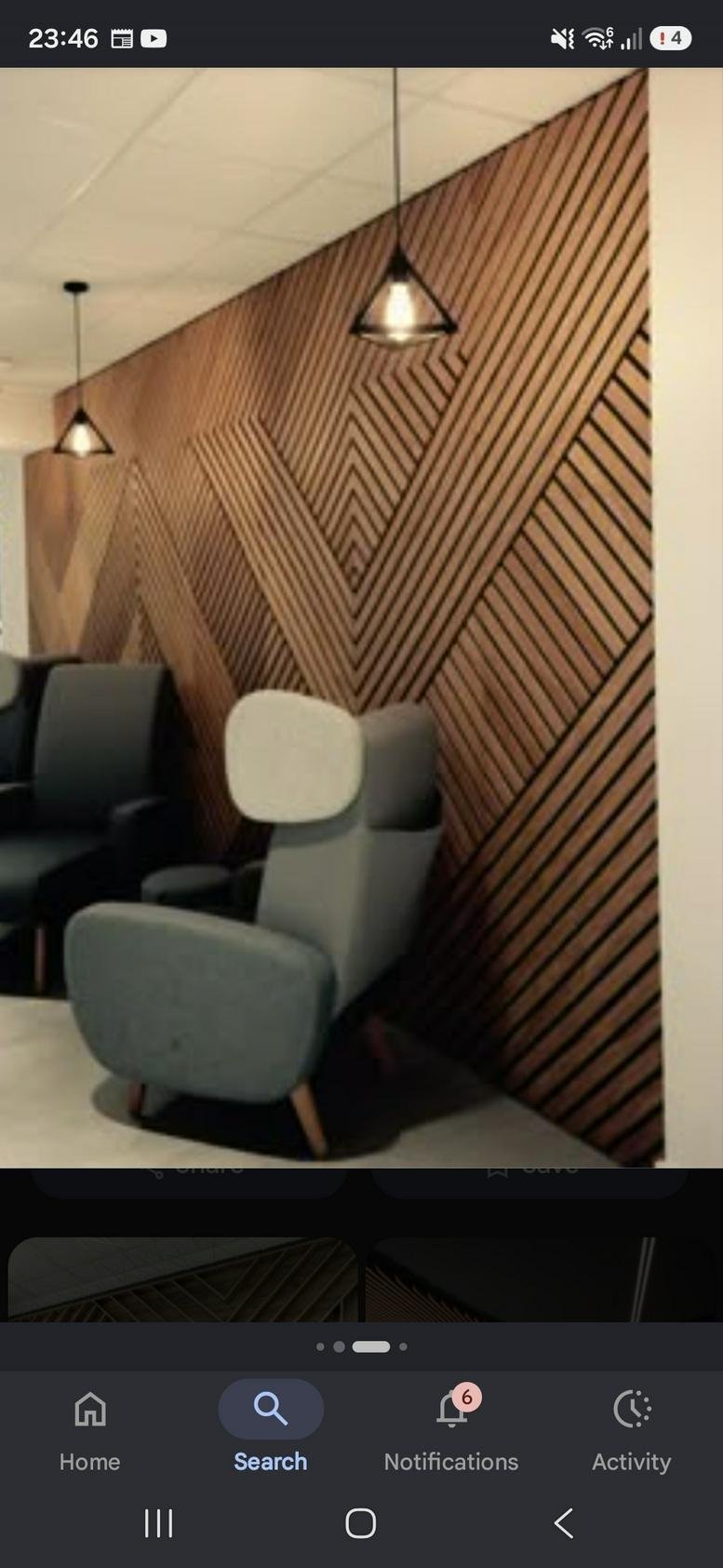 Reception area at 4a, Volta Street featuring a striking geometric wood slat feature wall and modern grey armchairs.