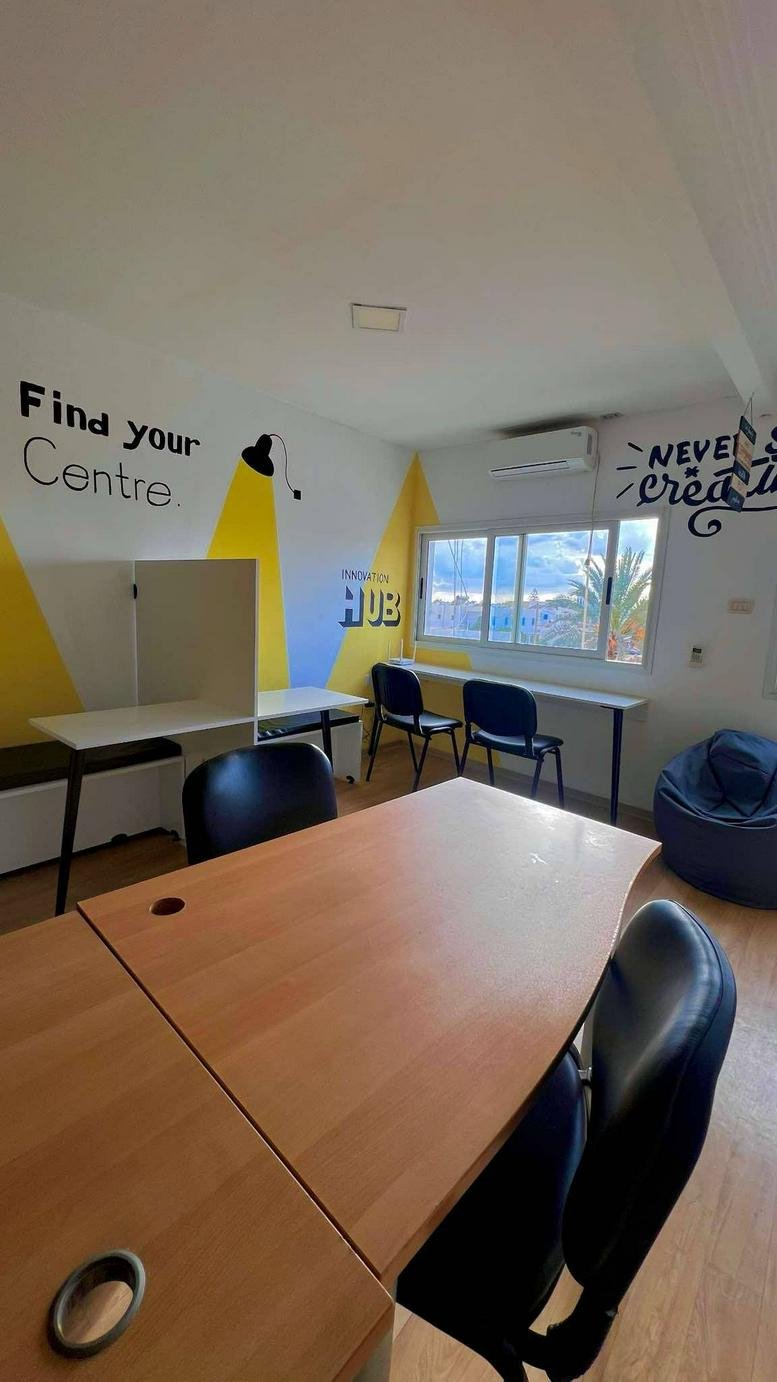 Bright coworking space at 12 Rue de la Municipalité, Houmt Souk featuring desks and vibrant wall art.